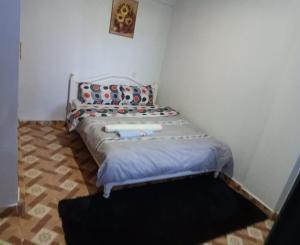 a small bedroom with a bed in a room at Megs Place -Maroon - Embu Town in Embu