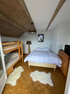 a bedroom with a bed and two bunk beds at Appartement au Sauze vue montagne in Enchastrayes