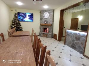 a dining room with a table and a christmas tree at Кам'яний двір in Mykulychyn