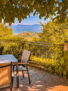 a wooden chair sitting on a patio with a table at Kreuzstein Bed&Breakfast in Appiano sulla Strada del Vino