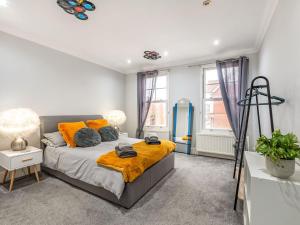 ein Schlafzimmer mit einem Bett mit orangefarbenen Kissen in der Unterkunft Walpole Heights Penthouse in Margate