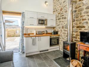 a kitchen with white cabinets and a stove at The Hayloft - Uk40092 in Bryngwyn