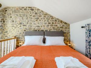 a bedroom with a large bed with a stone wall at The Hayloft - Uk40092 in Bryngwyn