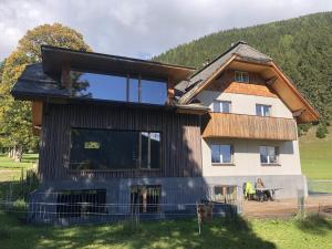 een huis met een groot raam aan de zijkant bij Alpenrose Boutique Chalet Gretl in Ramsau am Dachstein