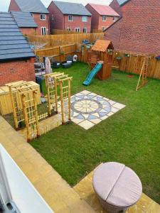 a small backyard with a playground with a play yard at Magnolia House in Nantwich