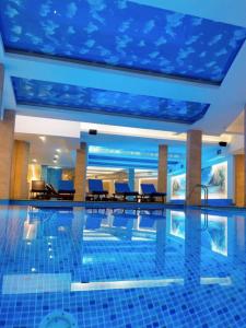 a swimming pool in a hotel with a blue ceiling at Milmari Apartman N92 Kopaonik in Kopaonik