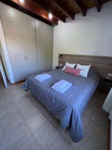 a bedroom with a large bed with blue sheets at Hermoso duplex con estacionamiento in Guaymallen