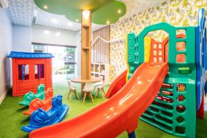 a play room with a slide and play equipment at Boulevard Beach Canasvieiras Hotel in Florianópolis