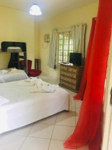 een slaapkamer met 2 bedden en een dressoir met een televisie bij Hotel Fazenda VCP in Silva Jardim