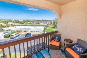 een balkon met stoelen en uitzicht op een parkeerplaats bij Unit 4307 - Ocean Racquet Club in Saint Augustine Beach