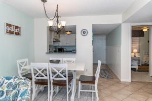 a dining room and kitchen with a white table and chairs at Unit 4307 - Ocean Racquet Club in Saint Augustine Beach