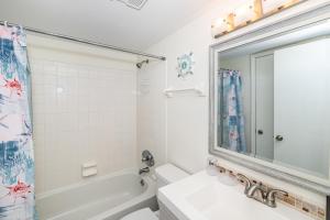 a bathroom with a tub and a sink and a mirror at Unit 4307 - Ocean Racquet Club in Saint Augustine Beach