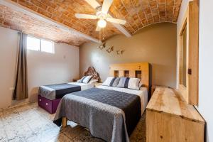 a bedroom with two beds and a ceiling fan at Meson del Conde in San Miguel de Allende