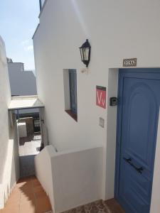 a blue door on a white wall with a staircase at Apartamento Tabayba Arena in Punta de Mujeres