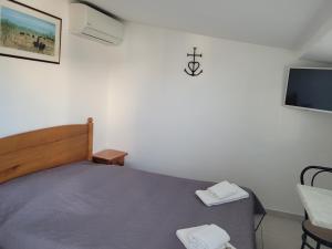 małą sypialnię z łóżkiem i telewizorem w obiekcie Le Mas de Mon Pere w Saintes-Maries-de-la-Mer