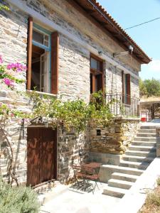 una casa in pietra con porta e scale in legno di Villa Appetite a Marmari