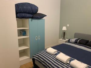 a bedroom with a bed and a blue cabinet with pillows at Appartement T2 Paray vieille poste Climatisé in Paray-Vieille-Poste