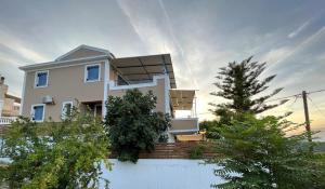 una casa blanca con una valla delante en Villa Thea - Τhe View 1st floor en Áno Yerakaríon