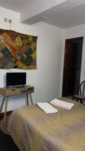 a bedroom with a bed and a desk with a laptop at Porto Riad - Guest House in Porto