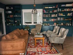 a living room with a couch and chairs and bookshelves at Villa Nature in Sarajevo