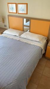a bedroom with a large bed with two pillows at Tristan casa vacanze a Roma in Casal Palocco