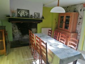 a dining room with a table and chairs and a fireplace at Le Dortoir de Gabrielle in Beaudéan