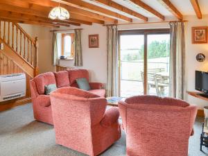 a living room with two chairs and a table at Merlin View in Saint Mawgan