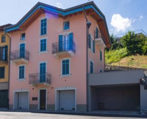 a pink house with a garage at APPARTAMENTO STELLA in Lezzeno