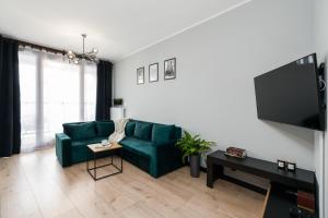 a living room with a green couch and a tv at Tumsky14 in Poznań