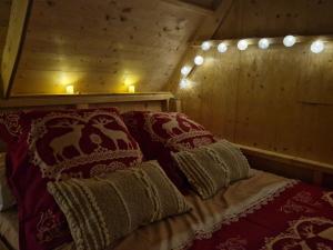 Bett in einem Zimmer mit zwei Kissen und zwei Kerzen in der Unterkunft Les cabanes féeriques du Cheix in Saint-Diéry