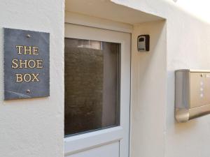 una puerta con una señal que lee la caja de zapatos en The Shoe Box, en Northam