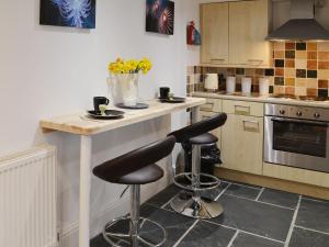 a kitchen with two bar stools and a counter at The Shoe Box in Northam