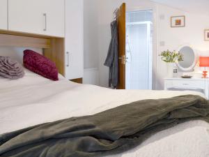 Un dormitorio con una cama con una manta. en The Shoe Box, en Northam