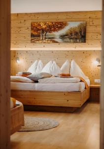 two beds in a bedroom with a wooden wall at Bauernhof Unterbichl in Flachau