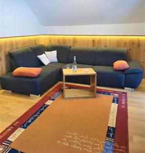 a living room with a blue couch and a table at Pension Ober in Siegsdorf