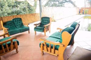 three chairs and a couch on a patio at Palm View Apartment in Pretoria
