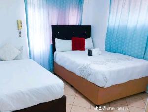 1 dormitorio con 2 camas y almohada roja en Palm View Apartment en Pretoria