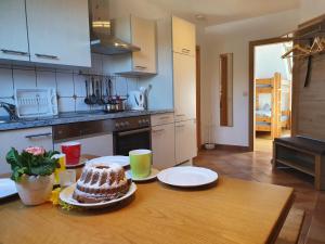 a kitchen with a table with a cake on it at Pension Ober in Siegsdorf