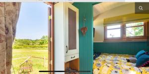 1 dormitorio con 1 cama y ventana en Shepherds Hut with Scandinavian Hot Tub and hydromassager en Sway