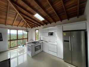 a kitchen with a stainless steel refrigerator and white cabinets at Glamping Ancestros Ecoparque in Girardota