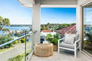 balcone con sedia e vista sull'acqua di Huge Bayside Luxury Resort-Style Home with Pool a Burraneer