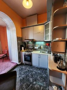 a kitchen with white cabinets and a stove top oven at Apartment at Baratashvili 10 in Tbilisi City