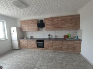 a kitchen with wooden cabinets and a white refrigerator at Будинок де є басейн та дві бесідки in Kyiv