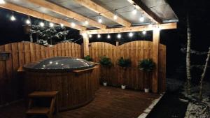 a wooden fence with a jacuzzi tub and lights at Agroturystyka Blicharzówka Noclegi in Bukówka +35 photos