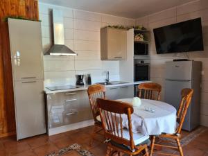 a kitchen with a table and chairs and a television at Finca Tropical in Arico Viejo