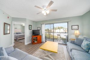 a living room with a couch and a tv at Beach Condo Getaway in Saint Augustine