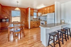 a kitchen with wooden cabinets and a table and chairs at Tarpon Drive Hideaway Unit B in Avon