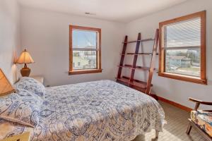 a bedroom with a bed and two windows at Tarpon Drive Hideaway Unit B in Avon