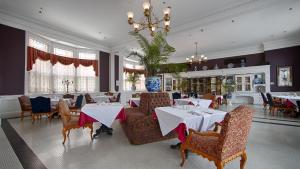 a restaurant with tables and chairs and a chandelier at Windsor Hotel, Ascend Hotel Collection in Americus
