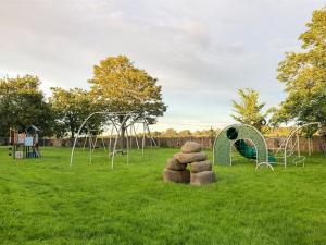 a group of playground equipment in a grass field at Brodie Cottage in Aspatria